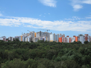 Residential modern apartment house, green forest and blue sky