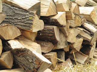 Background of dry chopped firewood logs and hay