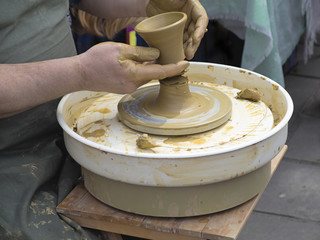 Hands of a potter, taking ready earthen jar