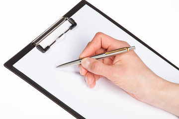 Closeup of a human hand writing with pen on clipboard