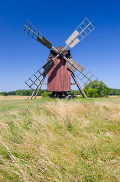 Red wooden windmill on the summer field