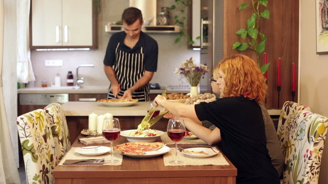 Man preparing lunch for women at home