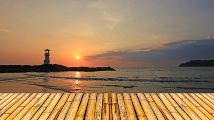 Lighthouse with sunset of thailand sea with bamboor floor