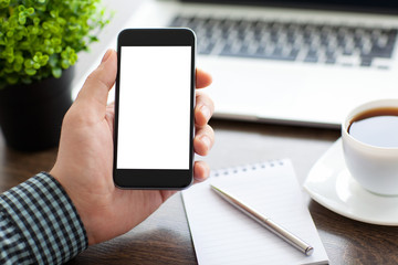 man holding a phone with isolated screen over the desk