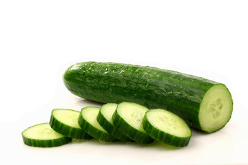 fresh cucumber and some cut pieces on a white background