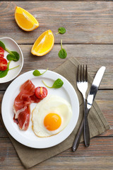 Bacon and eggs on rustic wooden planks background