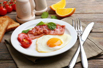 Bacon and eggs on rustic wooden planks background