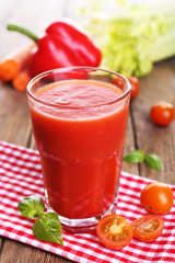 Glass of tomato juice with vegetables on wooden table close up