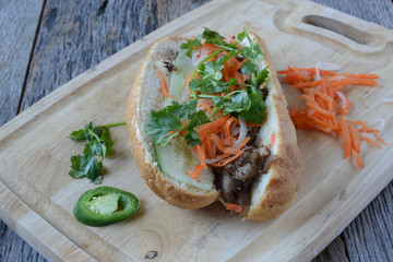 Vietnamese Grilled Pork Banh Mi Sandwich on Rustic Wood Backgrou