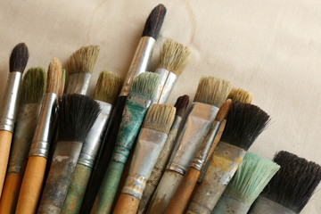 Fototapeta premium Different paintbrushes on fabric background