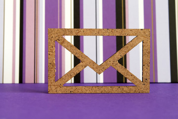 Wooden envelope icon on purple striped background