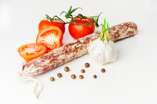 Smoked sausage and tomatoes on white background