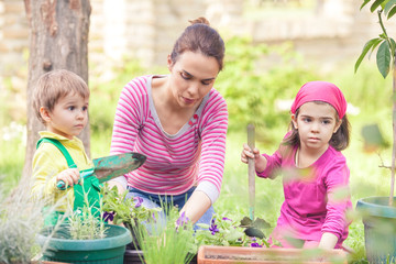 Mother gardening with her cute little son and 