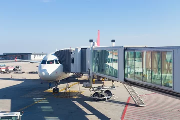 Photo sur Plexiglas Aéroport Jetway conecting plane to airport departure gates.