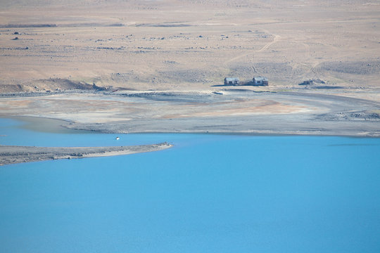 Two abandoned houses on the shore of a clean mountain lake in a