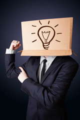 Businessman gesturing with a cardboard box on his head with ligh