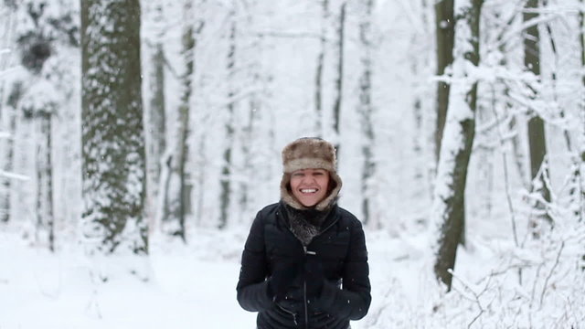 Happy girl jumping in the winter forest, slow motion