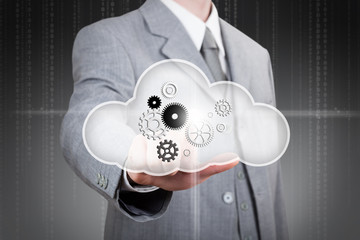 business man pointing at set of gears in the cloud
