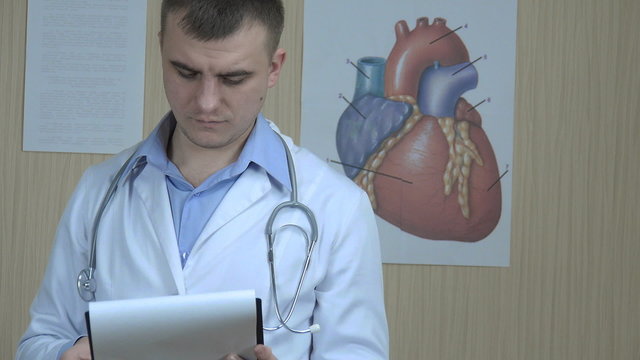 physician reviews the paper,  close-up