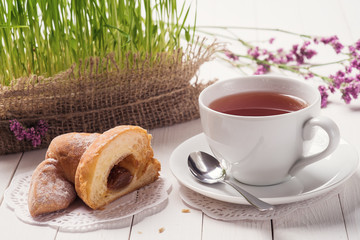 Cup of black tea with a croissant