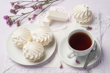 Cup of black tea with marshmallows and fruit candy