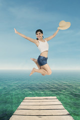 Female tourists jump on the pier