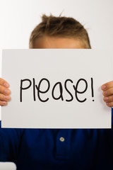 Child holding Please sign
