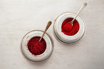 saffron spice threads and powder  in vintage  old dishes - 79050952