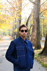 Portrait of man in jeans and sunglasses