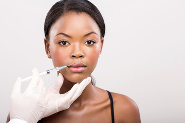 african girl receiving cosmetic injection on her lips