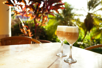 coffee latte in tall glasses with morning sun in summer cafe bac