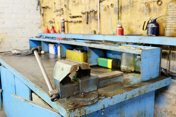 The image of a old vice on a metal workbench