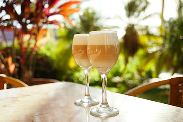 coffee latte in tall glasses with morning sun in summer cafe bac
