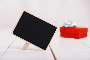Isolated black chalk board with red gift in the background.