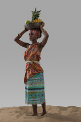 Attractive young african woman carrying fruits - obrazy, fototapety, plakaty
