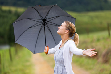 woman with arms open holding umbrella