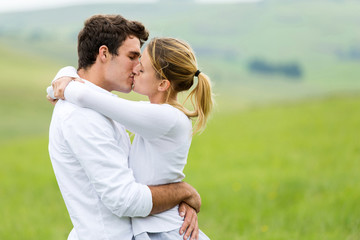 romantic couple kissing on grassland