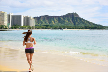 Female runner woman running jogging on beach run