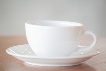 Obraz na płótnie Canvas White coffee cup on wooden table