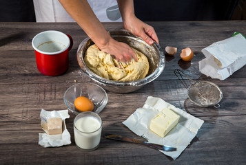 Cooking and home concept - close up of female hands kneading dou