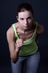 beautiful sporty woman running over grey