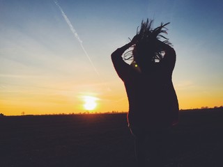 Mädchen springt vor Abendhimmel