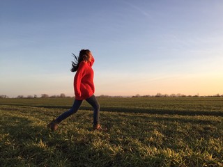 Frau springt &uuml;bers Feld