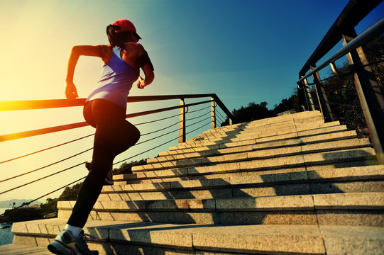 young fitness woman running on seaside stone stairs