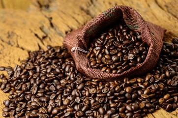 Roasted coffee beans in bag and coffee beans around
