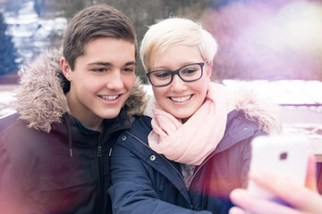Young Girl and Boy making Selfie Outdoors