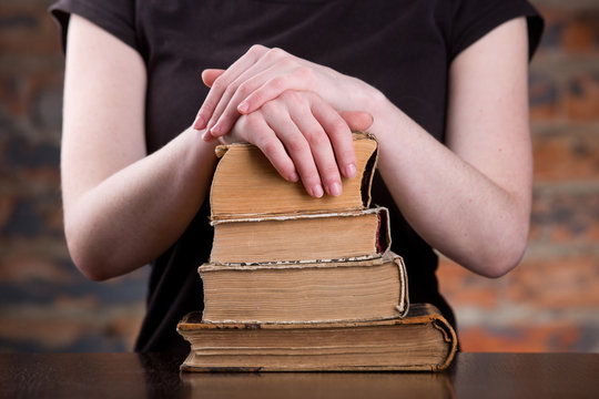 A woman two hands over a books