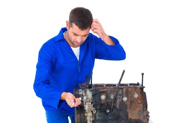 Confused mechanic repairing car engine