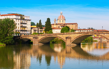 Florence, bridge through the river Arno is reflected in water