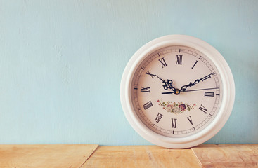 vintage white clock on wooden background